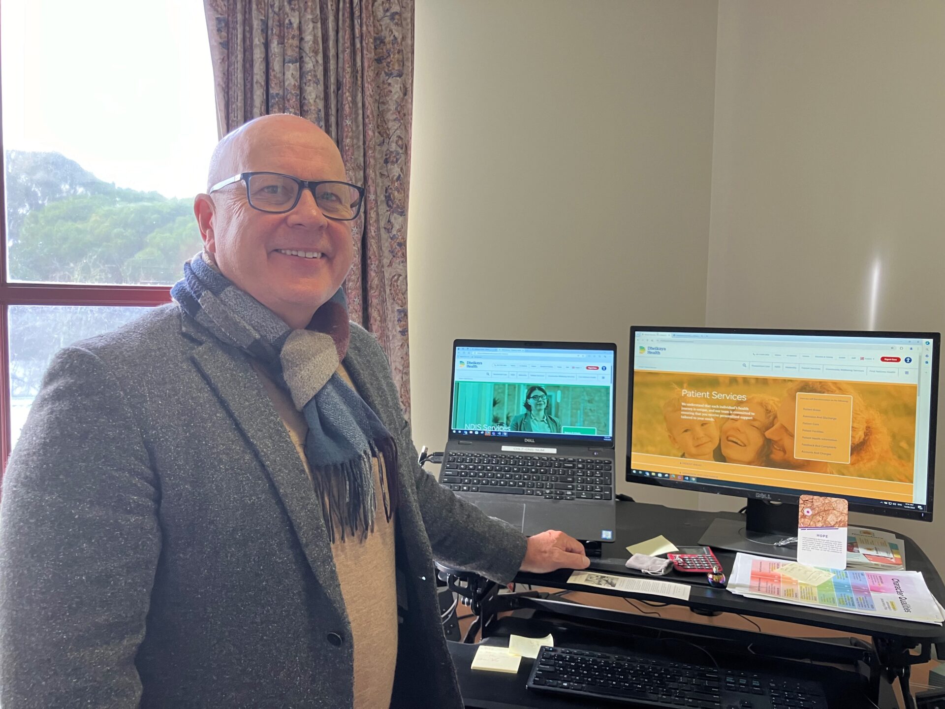 Photo of Darren Gaut, who heads up District Nursing and Palliative Care, in his office. He is smiling.