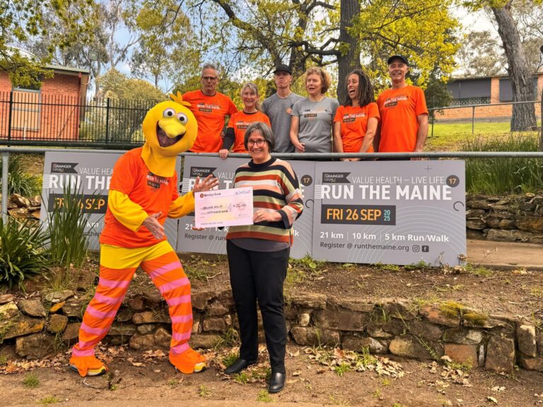Sue Race with The Bird and Run the Maine committee members. Sue is holding a cheque for $50k.