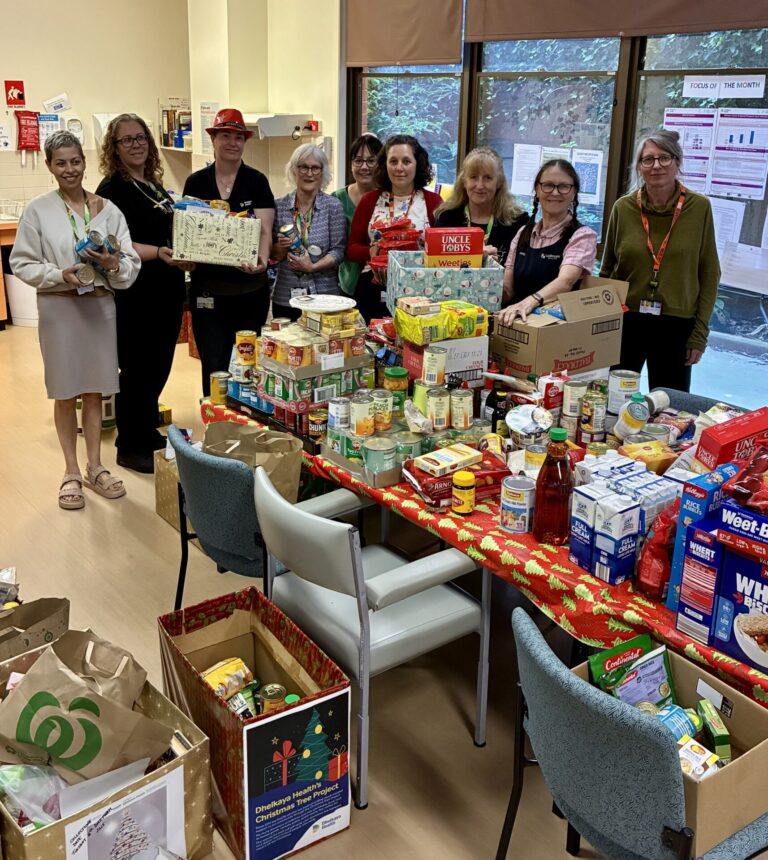 a group of staff holding hampers behind a table laden with non-perishable foods