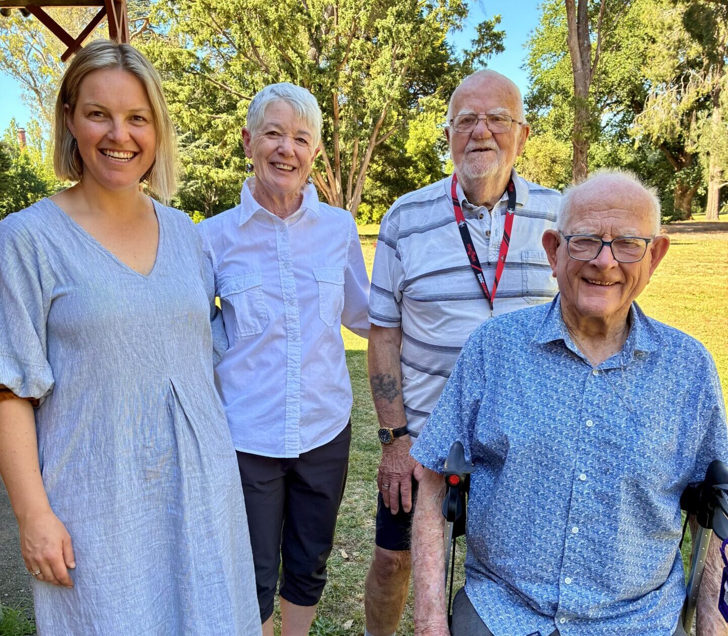 Community Health Nurse, Melodie Cameron standing with 3 participants of the walking group, one woman standing, one man standing and another man sitting on a wheely-walker.