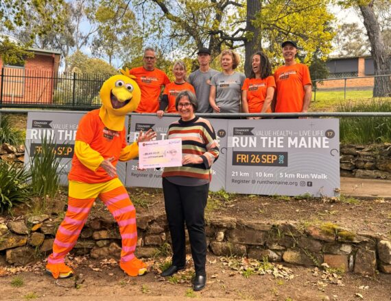 Sue Race with The Bird and Run the Maine committee members. Sue is holding a cheque for $50k.